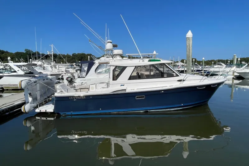  Yacht Photos Pics 2019 Cutwater C-28 boat docked in marina, reflecting on calm water under clear blue sky.