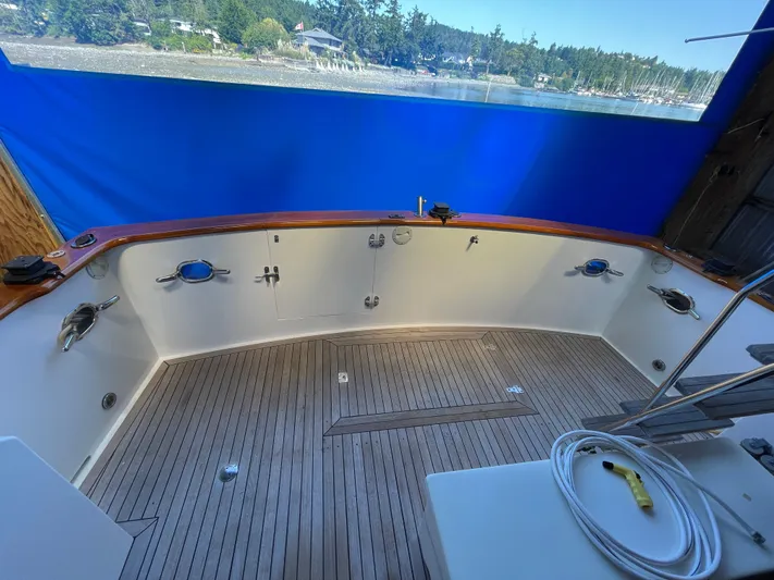 Wind Star Yacht Photos Pics 1993 Ocean Alexander 520 Pilothouse yacht deck with wooden flooring and blue backdrop.