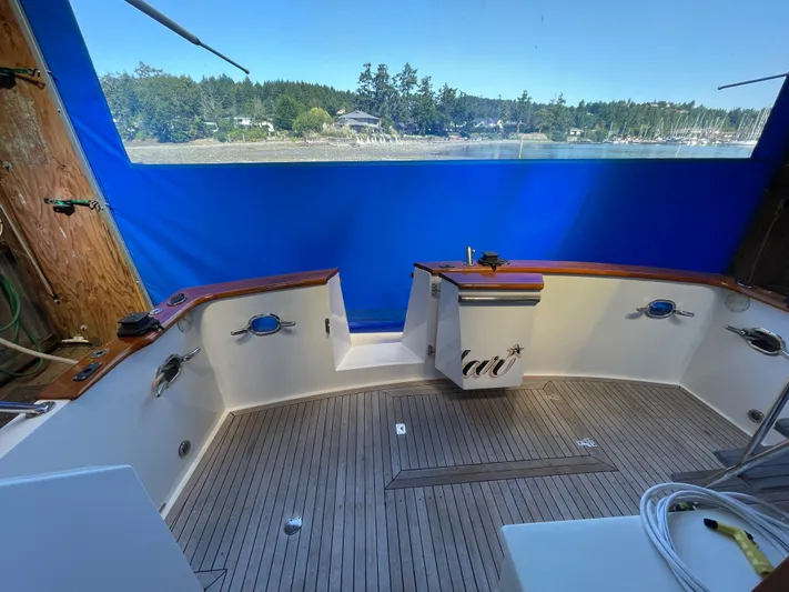 Wind Star Yacht Photos Pics 1993 Ocean Alexander 520 Pilothouse yacht deck with wood finish and blue canopy.