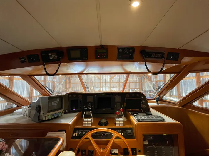 Wind Star Yacht Photos Pics Pilothouse interior of 1993 Ocean Alexander 520, featuring navigation equipment and wooden steering wheel.
