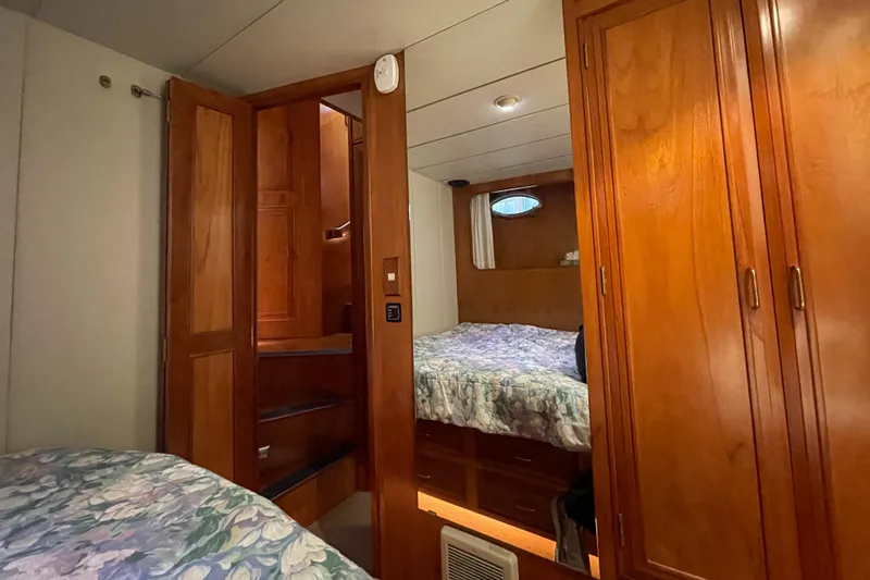 Wind Star Yacht Photos Pics Cozy cabin interior of 1993 Ocean Alexander 520 Pilothouse with wooden furnishings and bedding.
