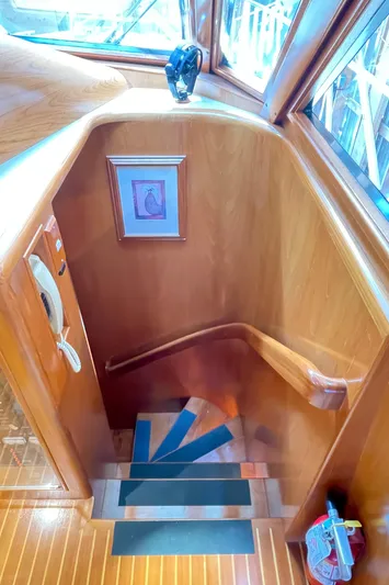 Wind Star Yacht Photos Pics Staircase in 1993 Ocean Alexander 520 Pilothouse with wooden finish and framed artwork.