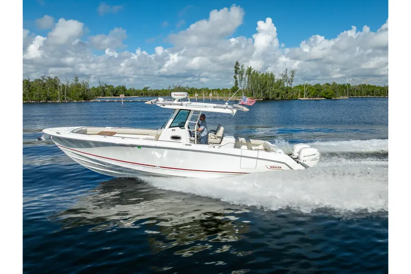 New Seakeeper- 110 Engine Hours- Obo Yacht Photos Pics 2017 Boston Whaler 330 Outrage cruising on a sunny day, with American flag flying.