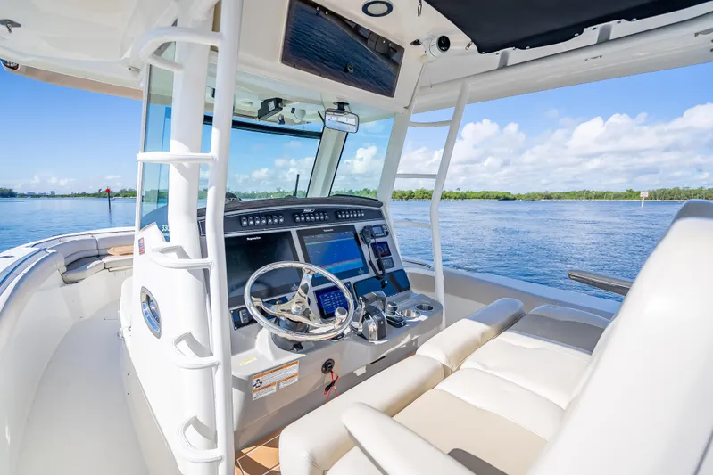 New Seakeeper- 110 Engine Hours- Obo Yacht Photos Pics 2017 Boston Whaler 330 Outrage boat interior with steering wheel and navigation system on a sunny day.