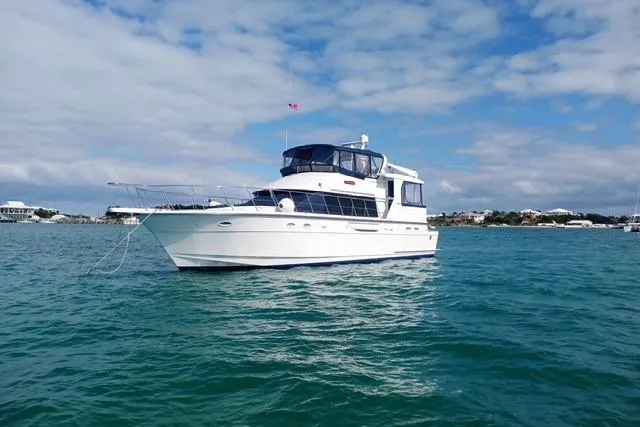 Traveller Yacht Photos Pics 1996 Jefferson 52 Rivanna Cockpit MY yacht on calm blue waters under a partly cloudy sky.