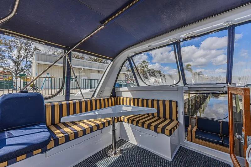 Traveller Yacht Photos Pics Interior of 1996 Jefferson 52 Rivanna Cockpit MY with striped seating and marina view.