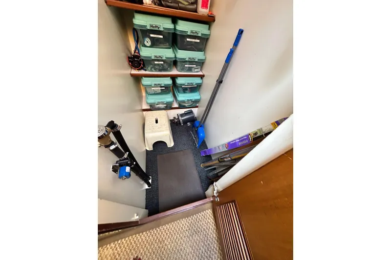 Traveller Yacht Photos Pics Storage area on a 1996 Jefferson 52 Rivanna Cockpit MY with organized shelves and cleaning tools.