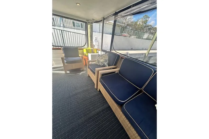 Traveller Yacht Photos Pics 1996 Jefferson 52 Rivanna Cockpit MY interior with wicker seating and navy cushions.