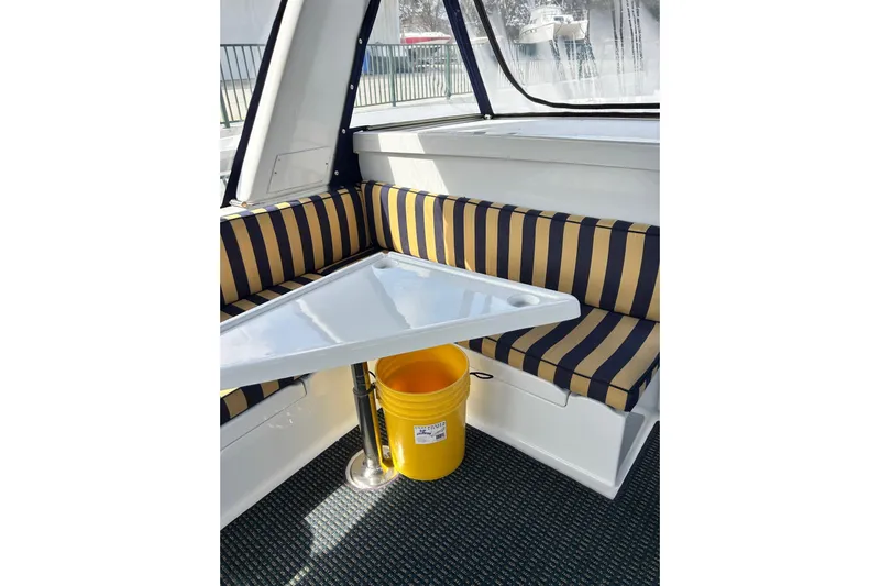 Traveller Yacht Photos Pics 1996 Jefferson 52 Rivanna Cockpit MY interior with striped seating and triangular table.