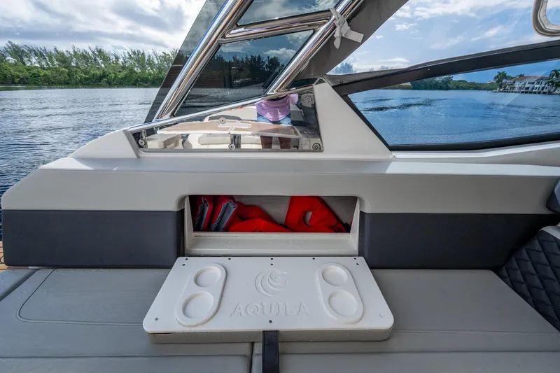  Yacht Photos Pics 2023 Aquila 32 Power Cat interior with storage compartment and scenic water view.
