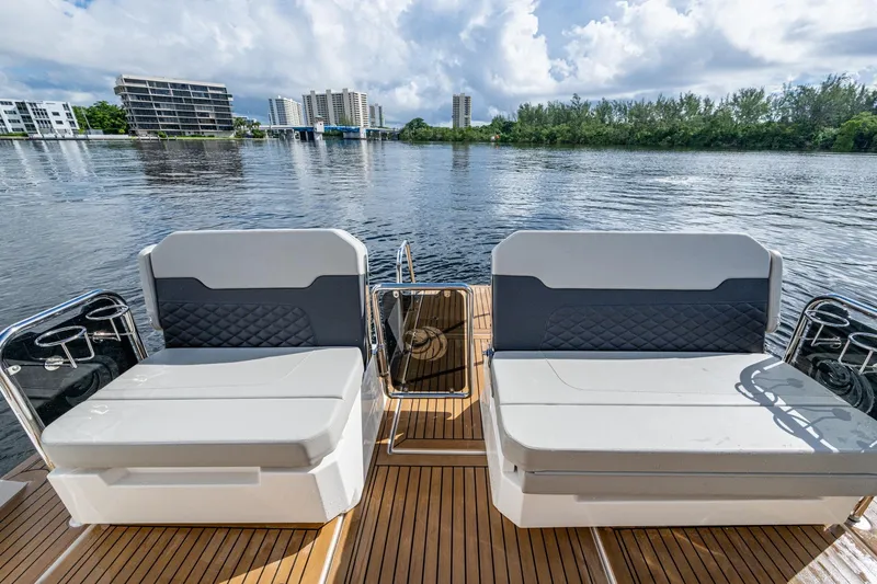  Yacht Photos Pics Aquila 32 Power Cat 2023 with stylish seating on a serene waterfront.