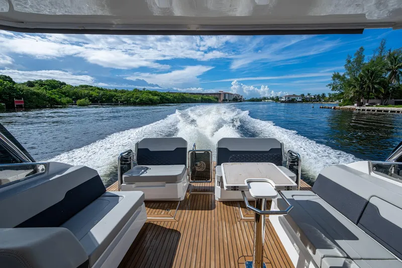  Yacht Photos Pics 2023 Aquila 32 Power Cat cruising on a scenic waterway with lush greenery.