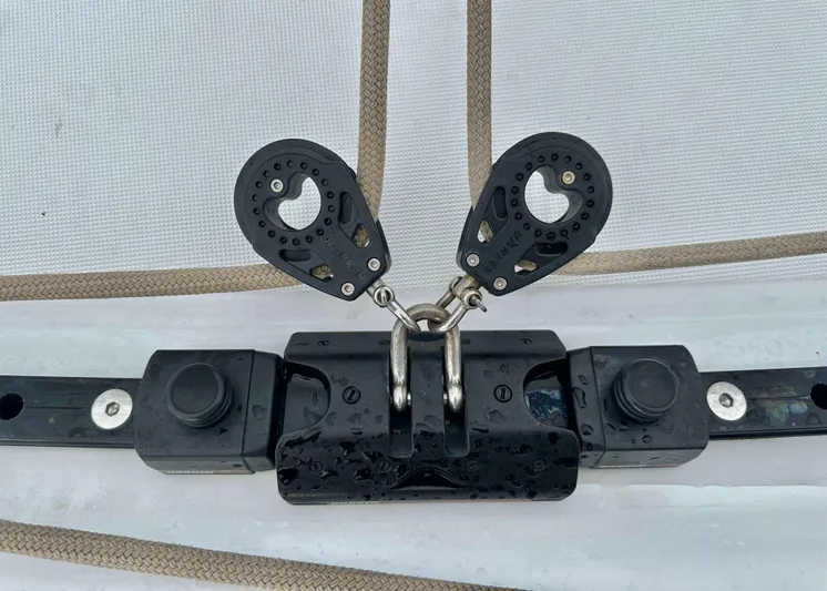 Drifter Yacht Photos Pics Close-up of a 2023 Lagoon 46 sailboat rigging component with pulleys and metal fittings.
