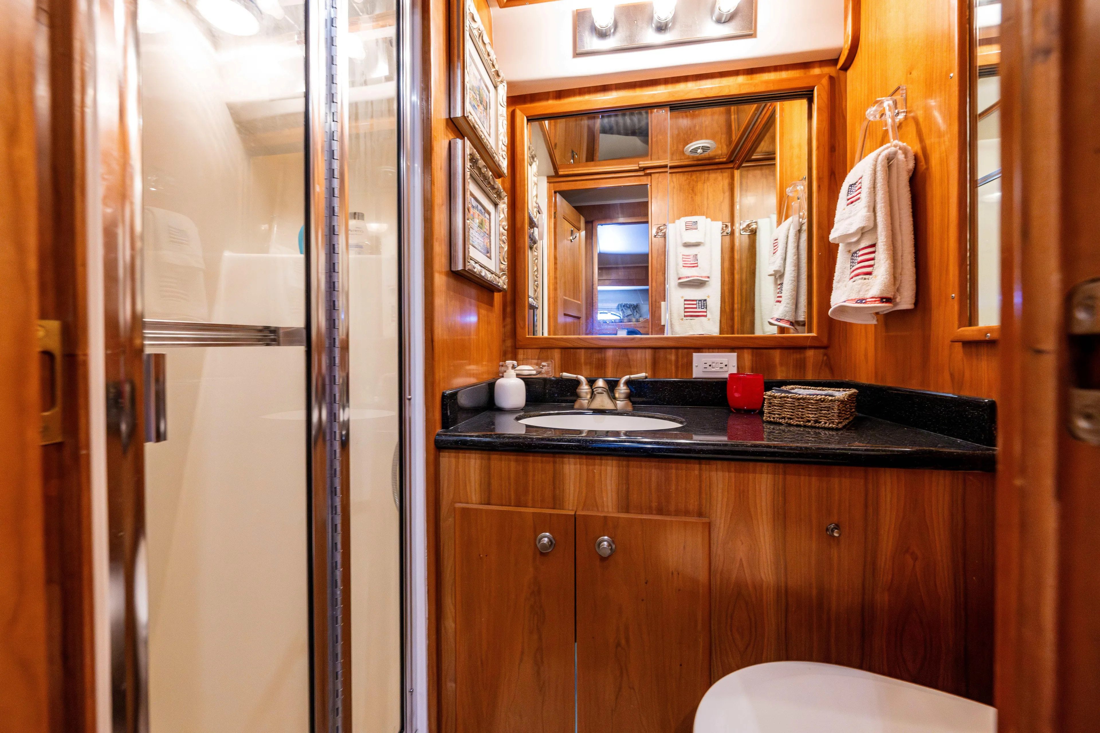 Clancy's Yacht Photos Pics Luxurious bathroom in 2004 Navigator Classic 5300 yacht with wood accents and modern fixtures.