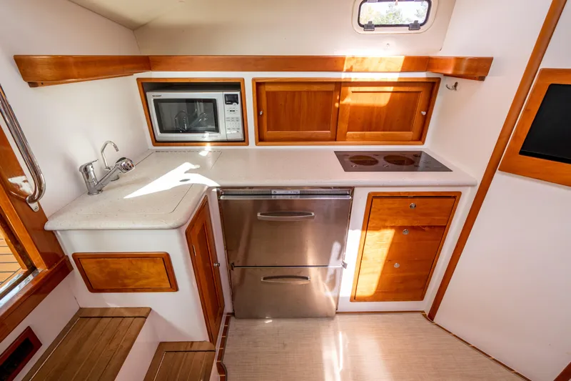 Ephemera Yacht Photos Pics Compact kitchen in a 2009 MJM 40z boat with wooden cabinets and modern appliances.