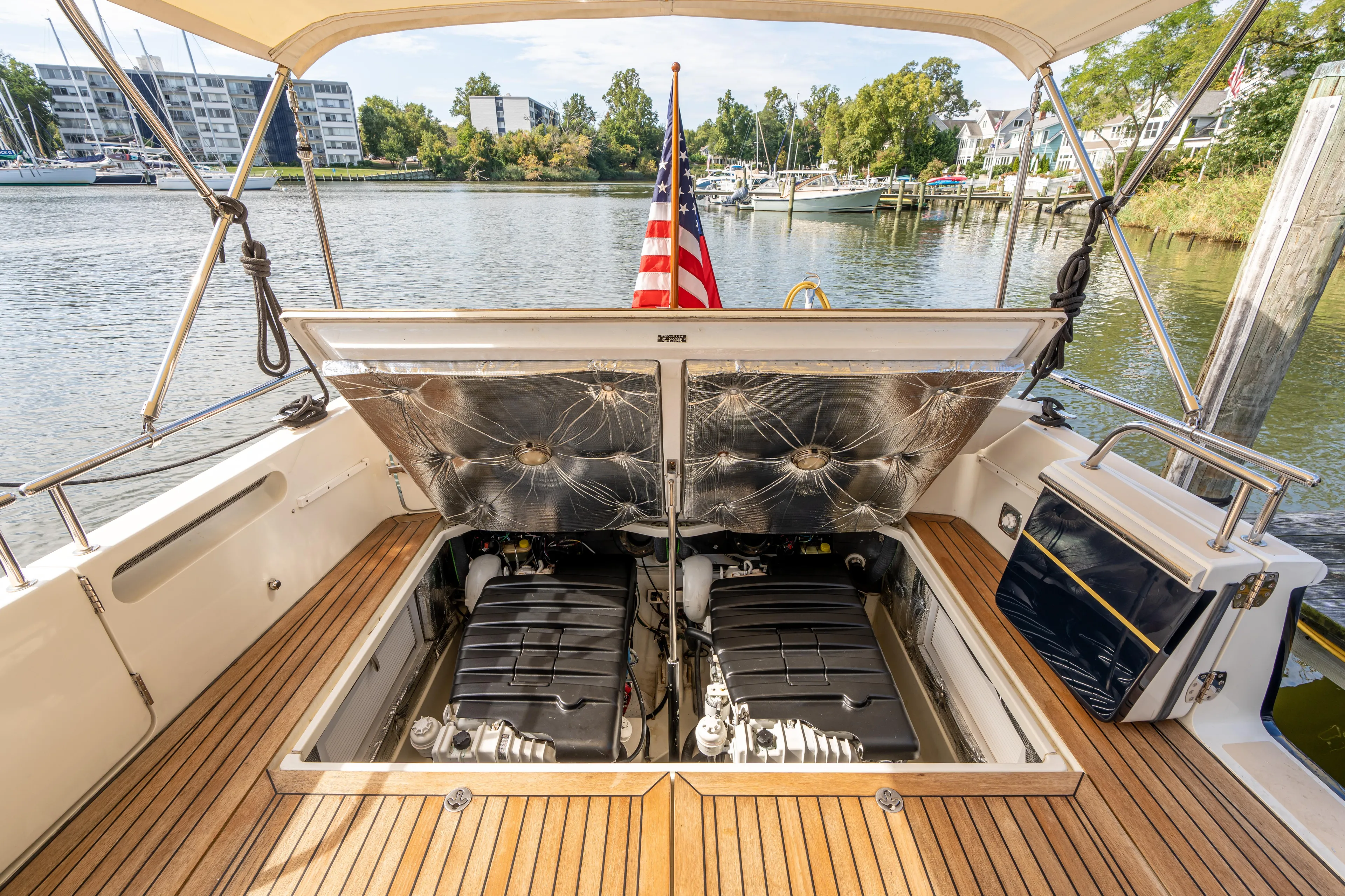 Ephemera Yacht Photos Pics 2009 MJM 40z yacht engine compartment with open hatches, docked by a scenic waterfront.