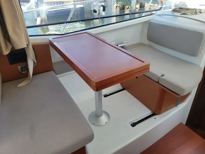 Supervielle Yacht Photos Pics Interior of 2016 Jeanneau Merry Fisher 855 with seating and wooden table.