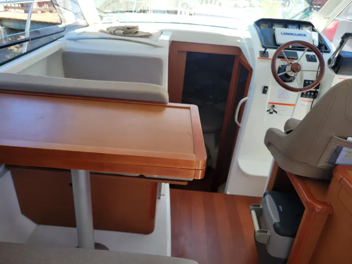 Supervielle Yacht Photos Pics Interior of 2016 Jeanneau Merry Fisher 855 with wooden table and steering console.