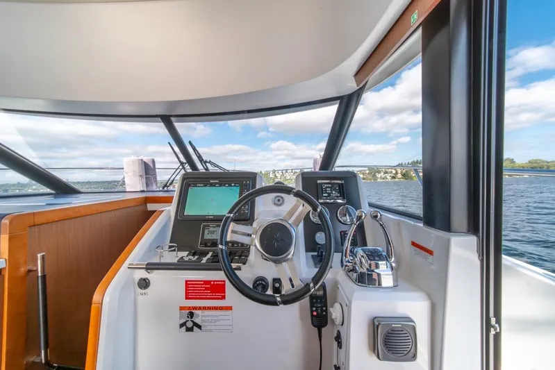  Yacht Photos Pics 2016 Jeanneau Velasco 43F helm with navigation equipment and scenic water view.