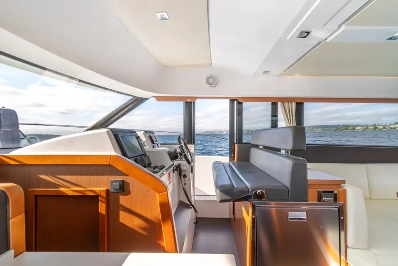  Yacht Photos Pics Interior of 2016 Jeanneau Velasco 43F yacht with modern helm and seating, overlooking the sea.