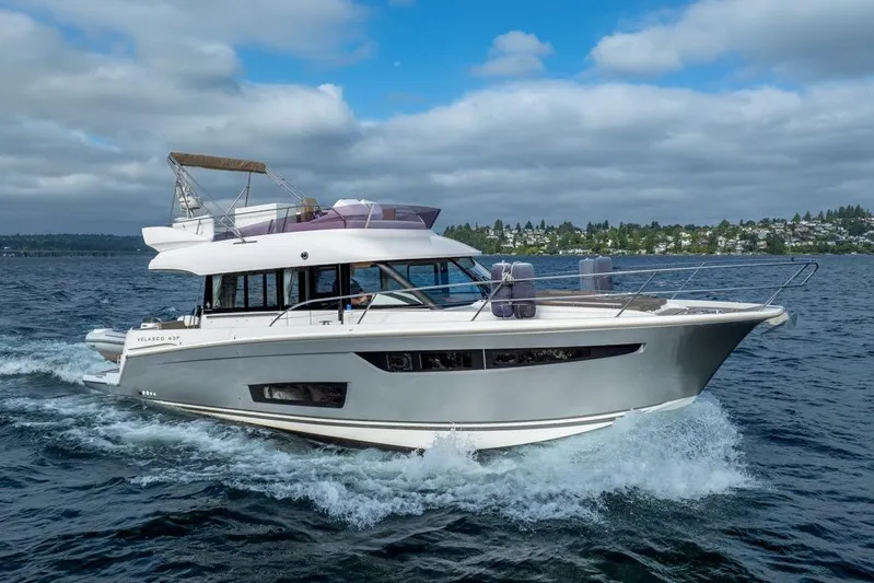  Yacht Photos Pics 2016 Jeanneau Velasco 43F yacht cruising on open water under a cloudy sky.