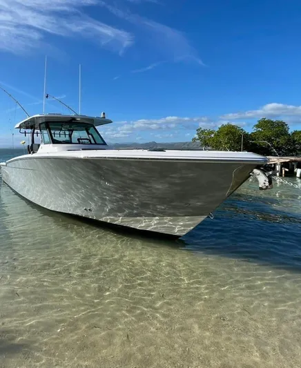  Yacht Photos Pics 2022 Bertram 39 CC boat docked in clear shallow water under a blue sky.