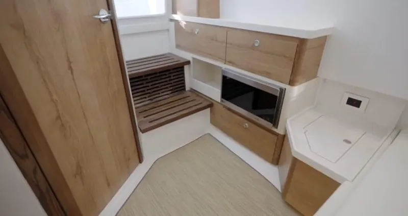  Yacht Photos Pics 2022 Bertram 39 CC interior with wooden cabinetry and modern appliances.