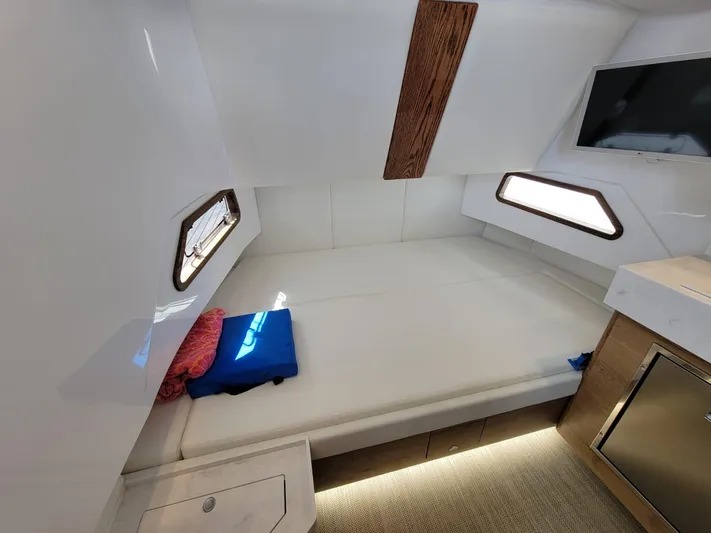  Yacht Photos Pics Interior cabin of 2022 Bertram 39 CC boat with bed, windows, and TV.