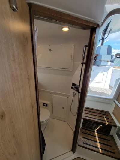  Yacht Photos Pics 2022 Bertram 39 CC boat interior bathroom with wooden accents and modern fixtures.