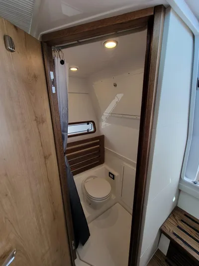  Yacht Photos Pics 2022 Bertram 39 CC boat bathroom with modern fixtures and wooden accents.