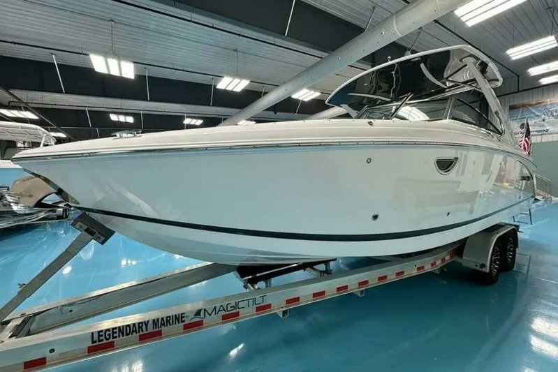  Yacht Photos Pics 2024 Cobalt 30SC Outboard boat on trailer in showroom, sleek design, white exterior.