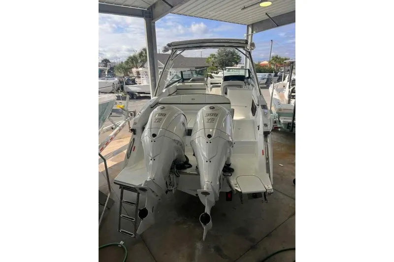 Yacht Photos Pics 2024 Cobalt 30SC Outboard boat with dual engines, docked under a covered area.