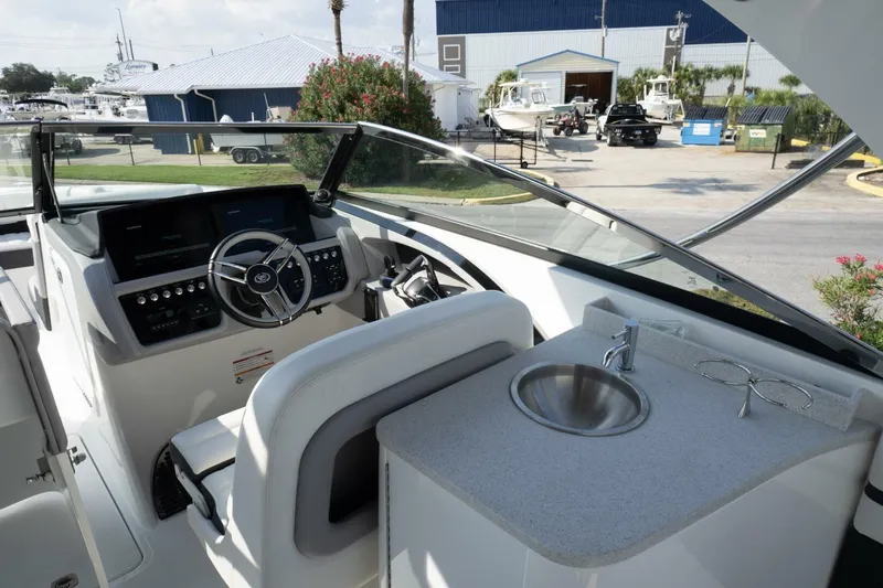  Yacht Photos Pics 2024 Cobalt 30SC Outboard boat interior with steering wheel and sink.