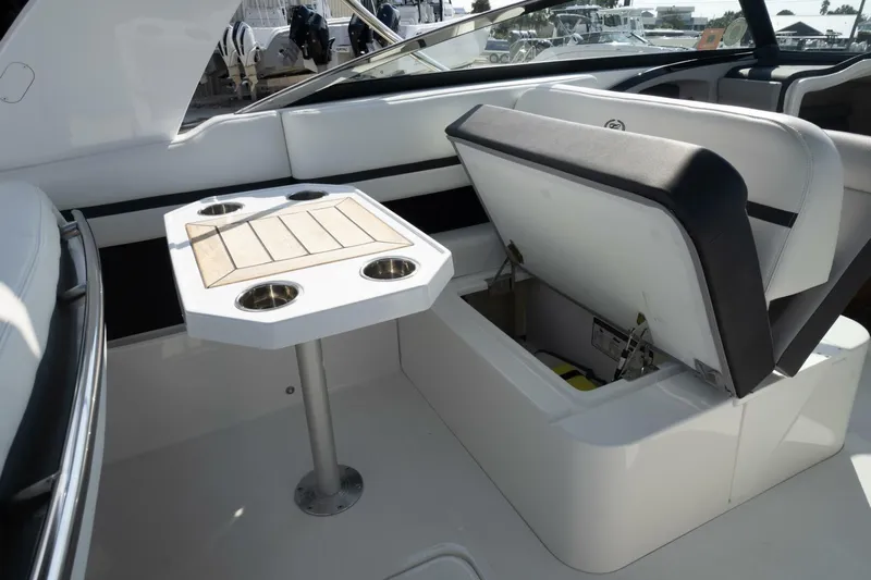  Yacht Photos Pics 2024 Cobalt 30SC Outboard interior with seating and table, showcasing storage compartment.