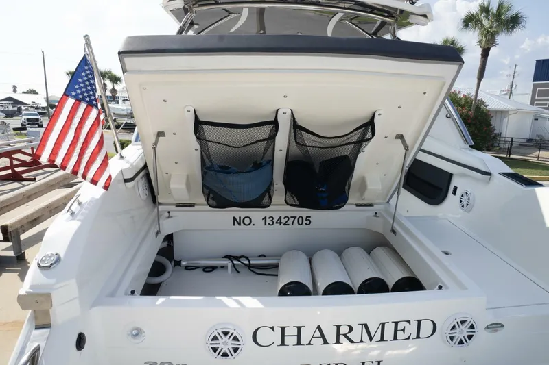  Yacht Photos Pics 2024 Cobalt 30SC Outboard boat with open storage compartment and American flag.