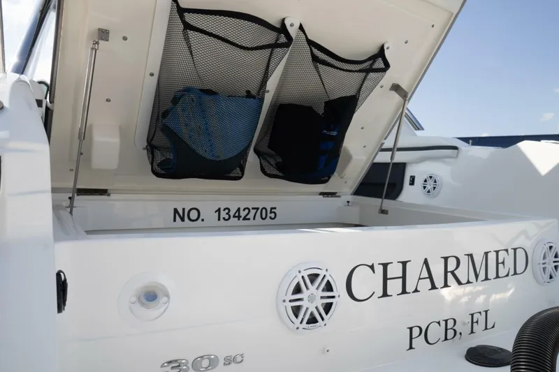  Yacht Photos Pics 2024 Cobalt 30SC Outboard boat with open storage compartment, labeled "CHARMED" and "PCB, FL".