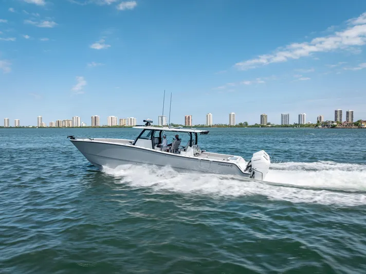  Yacht Photos Pics 2024 Freeman 43 boat cruising on water with city skyline in background.
