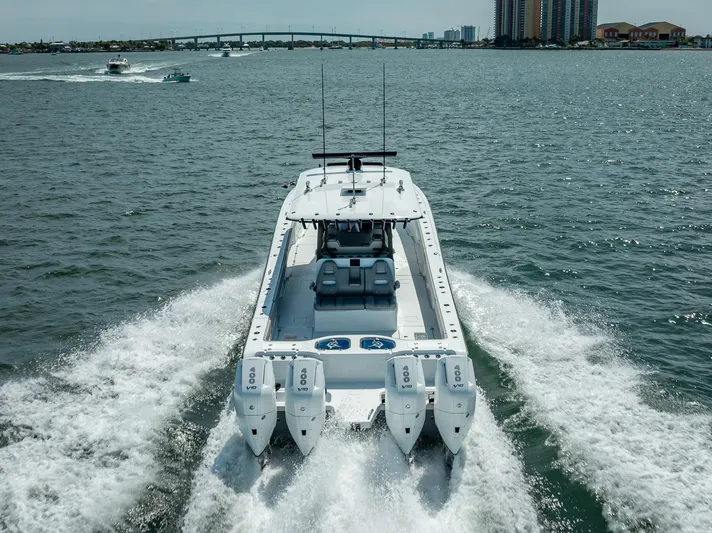  Yacht Photos Pics 2024 Freeman 43 boat cruising on open water with four engines, cityscape in background.
