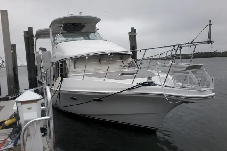 Aquarelle Yacht Photos Pics 2000 Bluewater 5800 Millenium yacht docked at marina on a cloudy day.