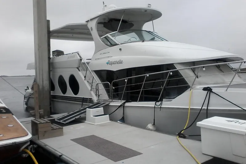 Aquarelle Yacht Photos Pics Luxury Bluewater 5800 Millenium yacht docked, 2000 model, sleek design, overcast sky.