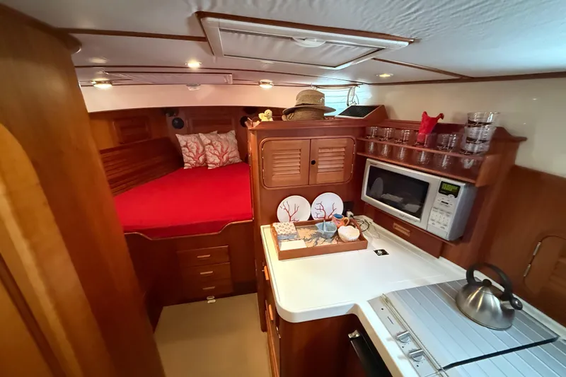 Brass Ring Yacht Photos Pics Cozy interior of 2003 Hinckley Talaria 40 yacht with bed, kitchenette, and microwave.