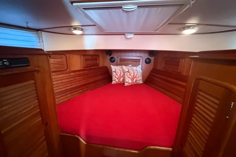 Brass Ring Yacht Photos Pics Cozy cabin interior of 2003 Hinckley Talaria 40 with red bedding and wooden finish.