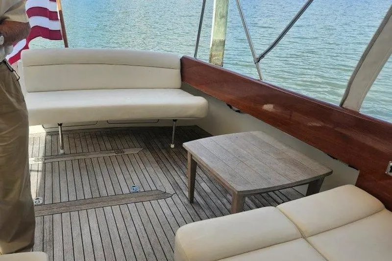 Brass Ring Yacht Photos Pics 2003 Hinckley Talaria 40 yacht interior with wooden deck, white seating, and small table.