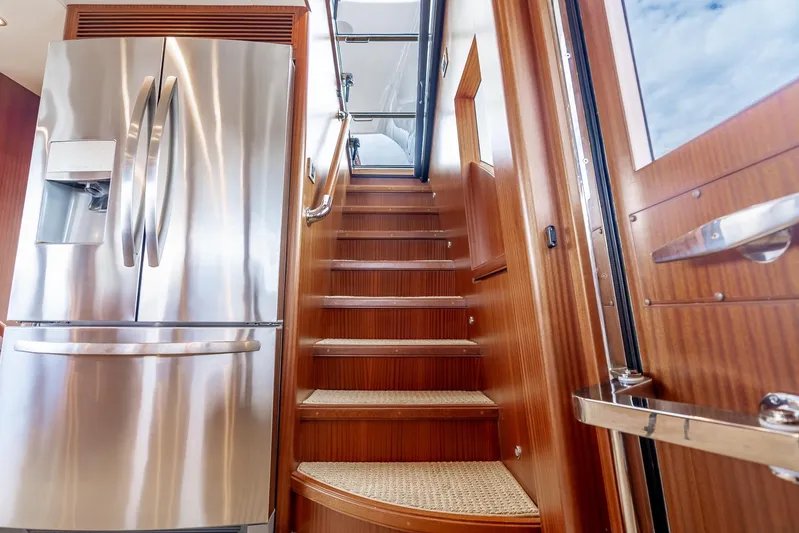 Whitefish Yacht Photos Pics Luxurious interior of 2013 Ocean Alexander 72 Pilothouse with stainless steel fridge and wooden stairs.
