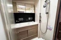 Modern bathroom in 2017 Hanse 548 yacht with shower, mirror, and wooden cabinetry.