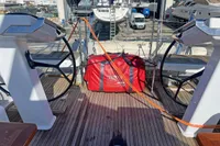 Deck of 2017 Hanse 548 yacht with dual steering wheels and red bag.