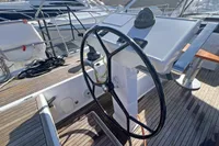 Steering wheel of a 2017 Hanse 548 yacht on a wooden deck.