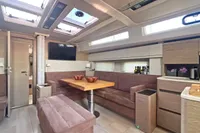Luxurious interior of 2017 Hanse 548 yacht with modern seating and dining area.