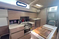 Modern kitchen interior of 2017 Hanse 548 yacht with wooden cabinetry and stainless steel appliances.