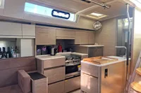 Luxurious interior of 2017 Hanse 548 yacht with modern kitchen and seating area.